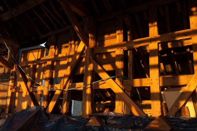 The warm light of the warming sunbeams glows yellow on the wooden beams